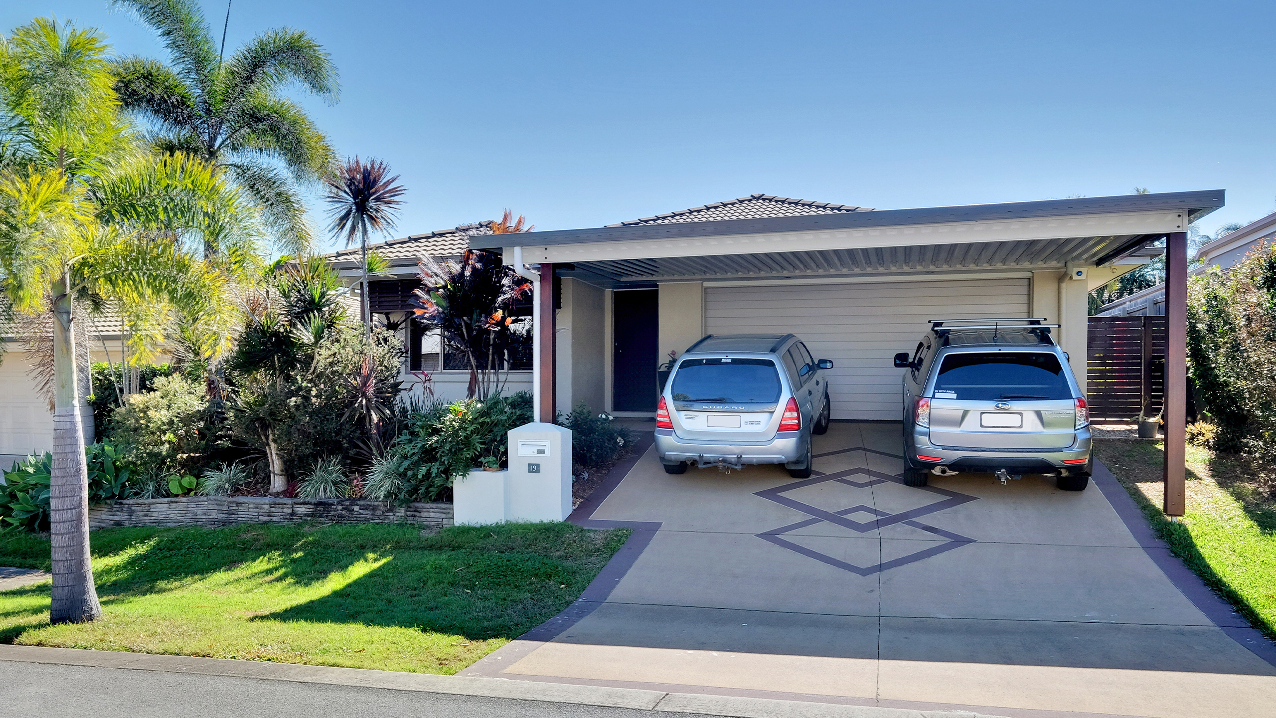 A double carport built by Altec with 2 vehicles in driveway.